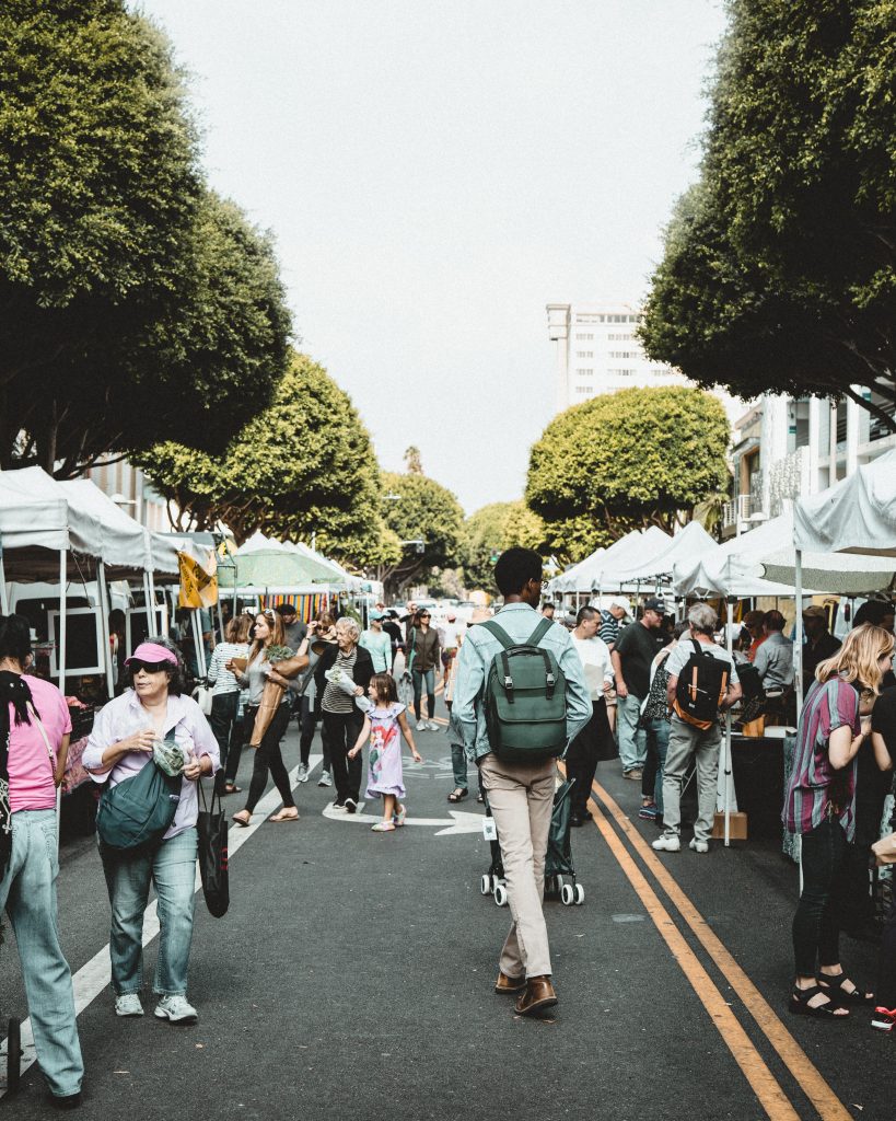 Many different people shopping at a street market connecting with local people while traveling 