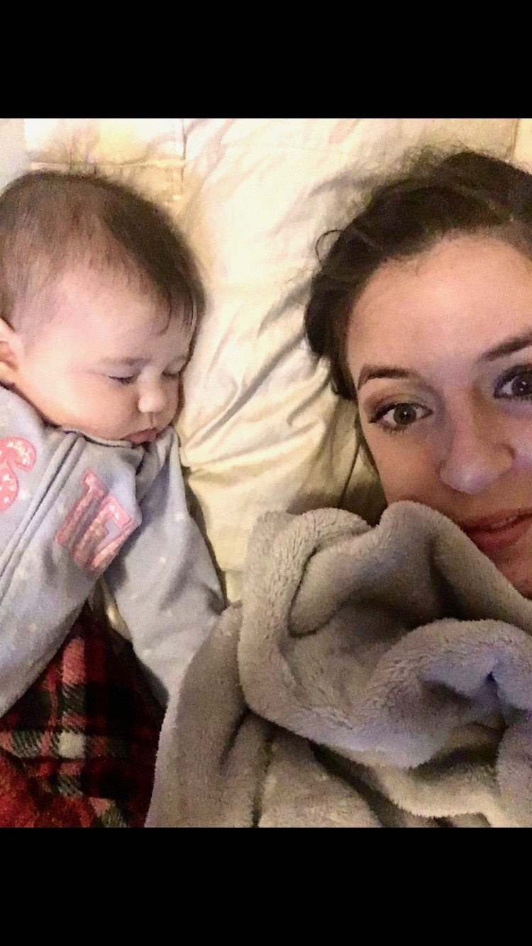 mom looking content as infant is sound asleep sharing the same bed