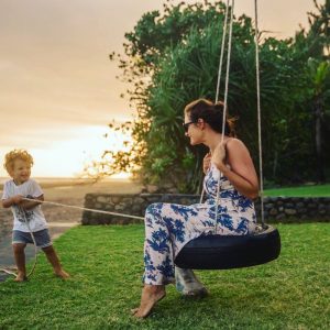 mom on a tire swing with a little boy