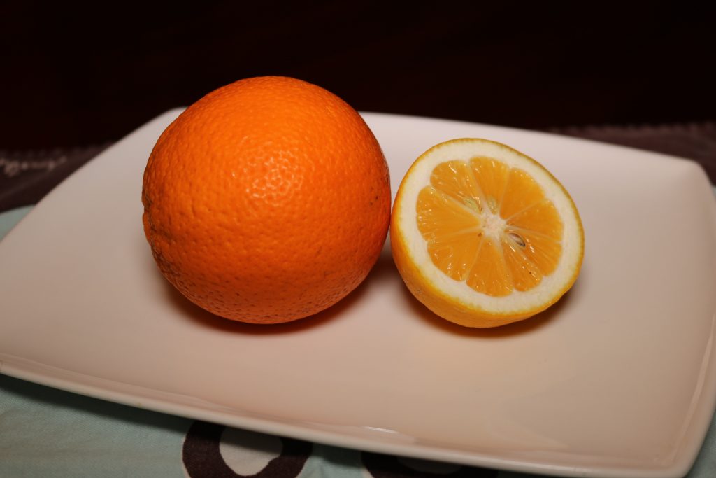 An orange and a cut in half orange to make your own essential oil room spray