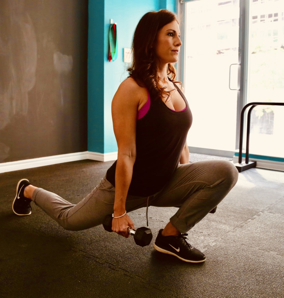 A woman lunge forward with workout weights in each hand