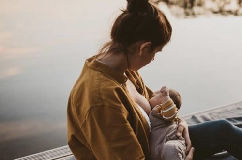 professional photo of mom breastfeeding her baby on boat dock