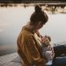 professional photo of mom breastfeeding her baby on boat dock