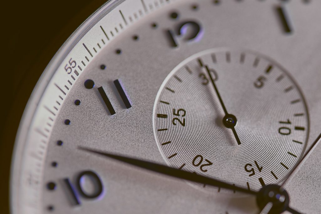 white clock with black numbers and second hand inside watch face