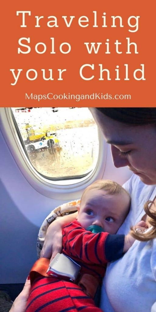 A mom holding her infant son close on her lap on an airplane