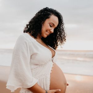 lady pregnant on the beach in white