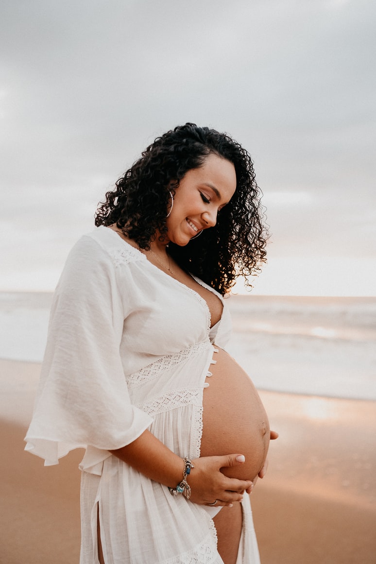 lady pregnant on the beach in white