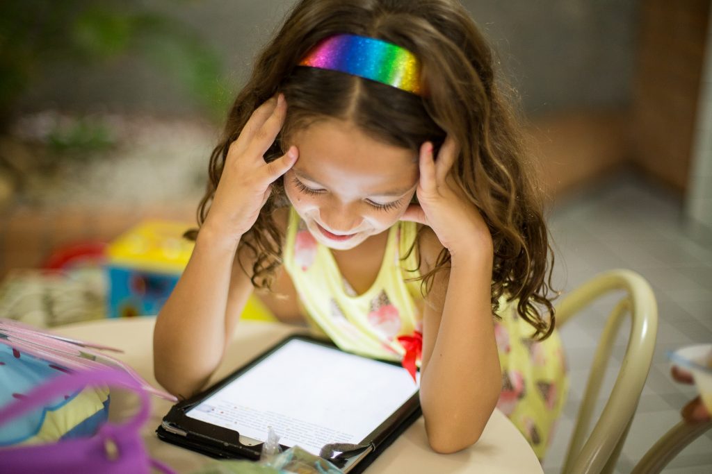 Young girl in yellow top passively having screen time