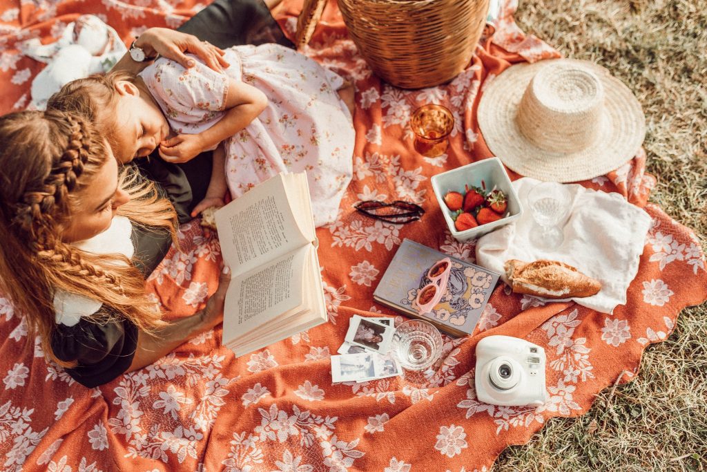 two girls having a picnic and reading books together