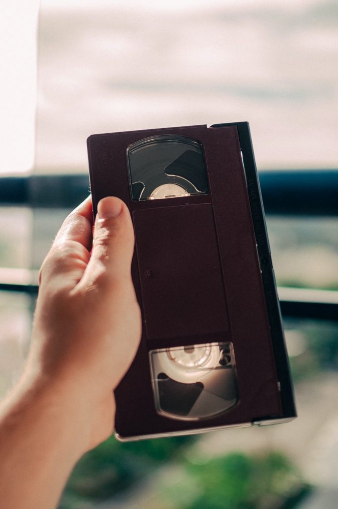 hand holding a VHS tape with landscape in the background