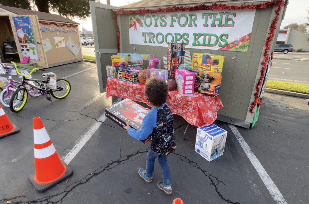 Five year old delivering gift for Toys for Tots.