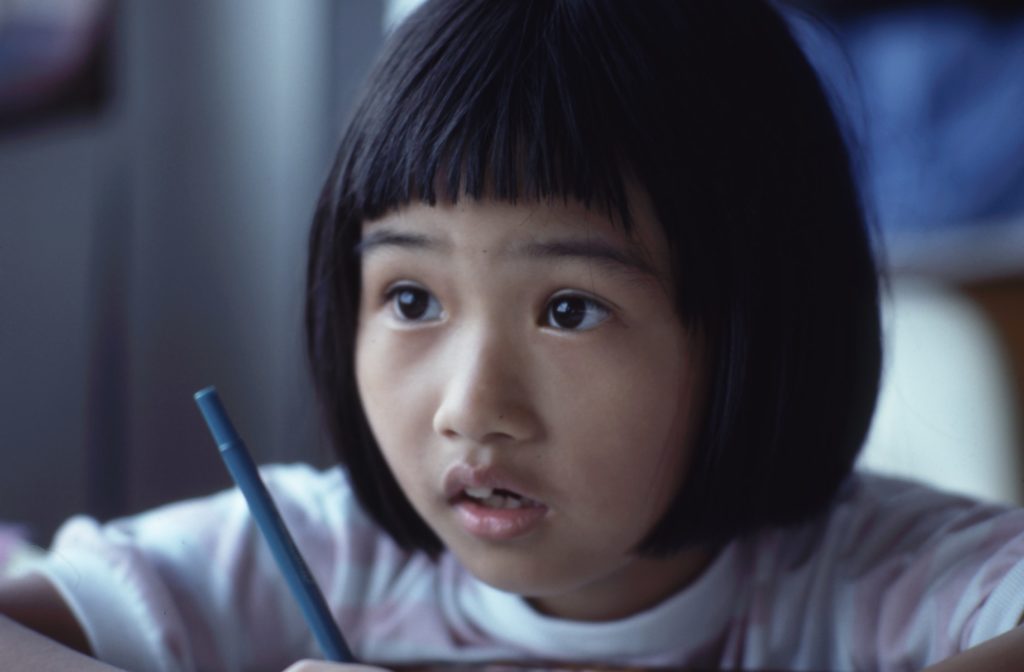 girl with black hair sitting a table studying