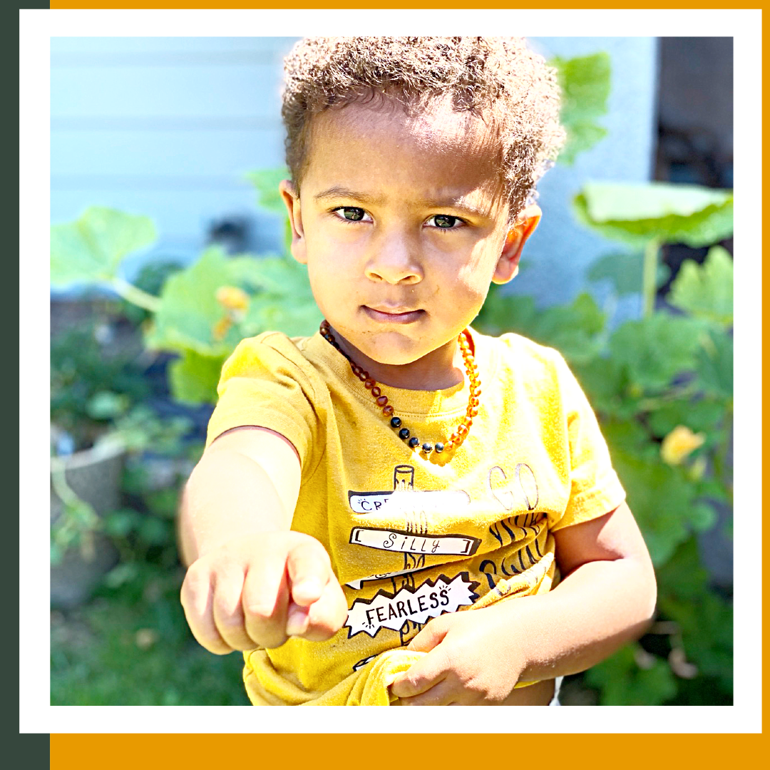 toddler in yellow shirt pointing his finger