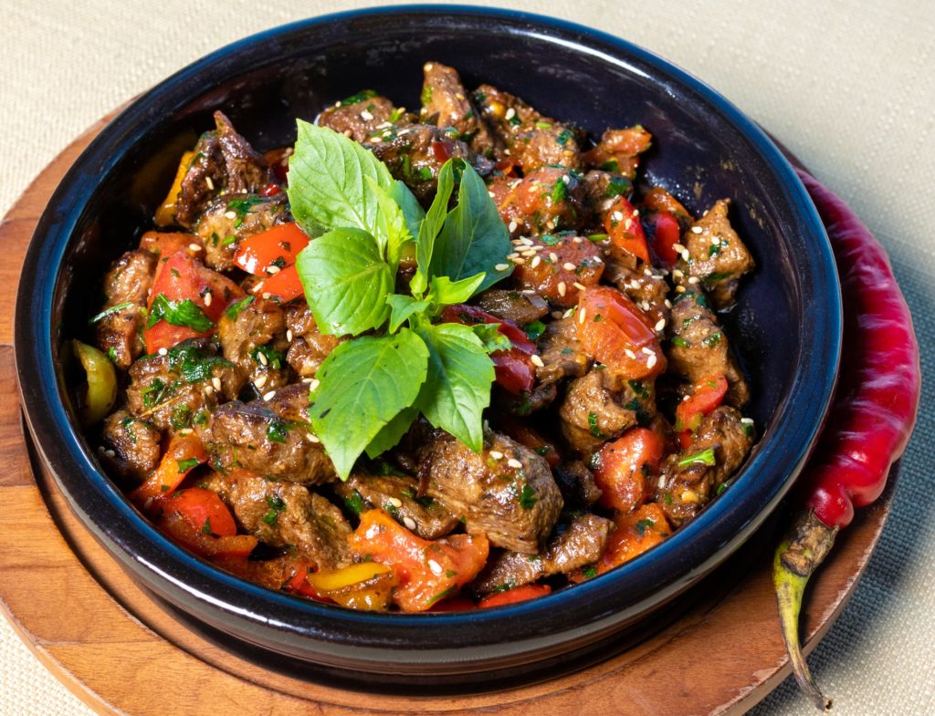 bowl of asian chili with mint in a black bowl sitting on a wood board