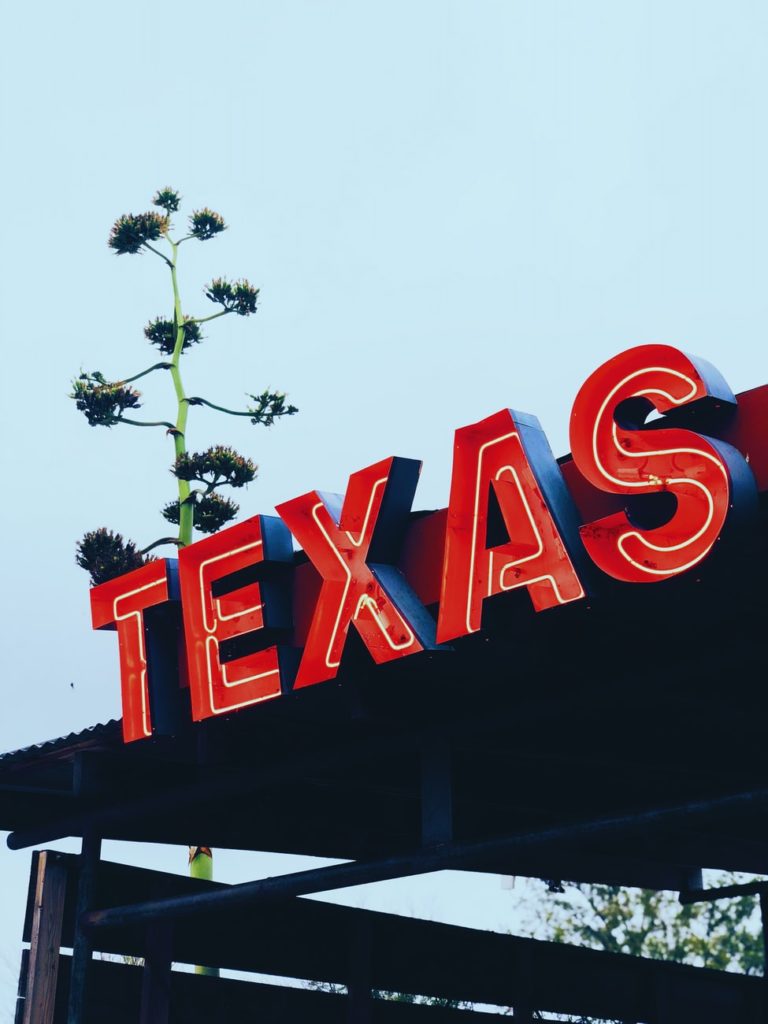 lighted sign of Texas in red