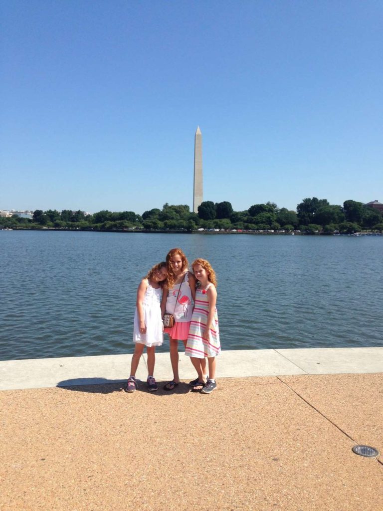 family travel photo of girls and the Washington Monument in Washington D.C.