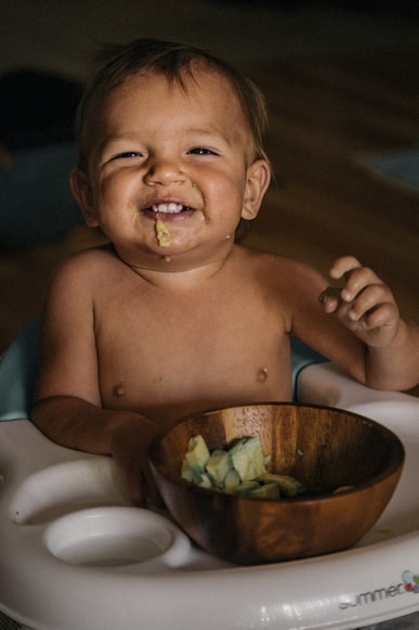 Baby eating avocados from a bowl