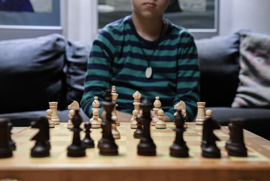 child sitting in front of chess board