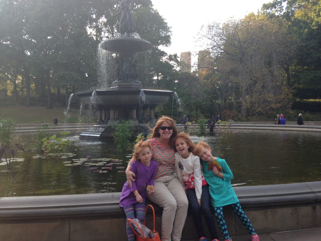 mom with three daughters by fountain